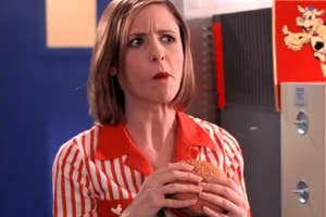 Person in a retro diner uniform holding a burger, looking thoughtful